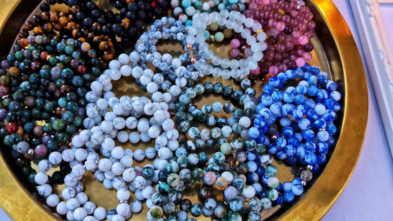 Close-up of colorful handmade bracelets made from a variety of natural stone beads displayed as a collection - push in