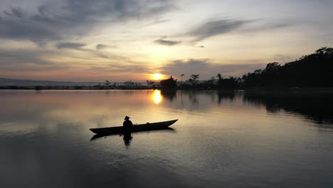 central java , indonesia - desember, 2021 : beautiful sunset in the afternoon from the lake rawa pening, with such beautiful colors, and epic moment boat of fisherman