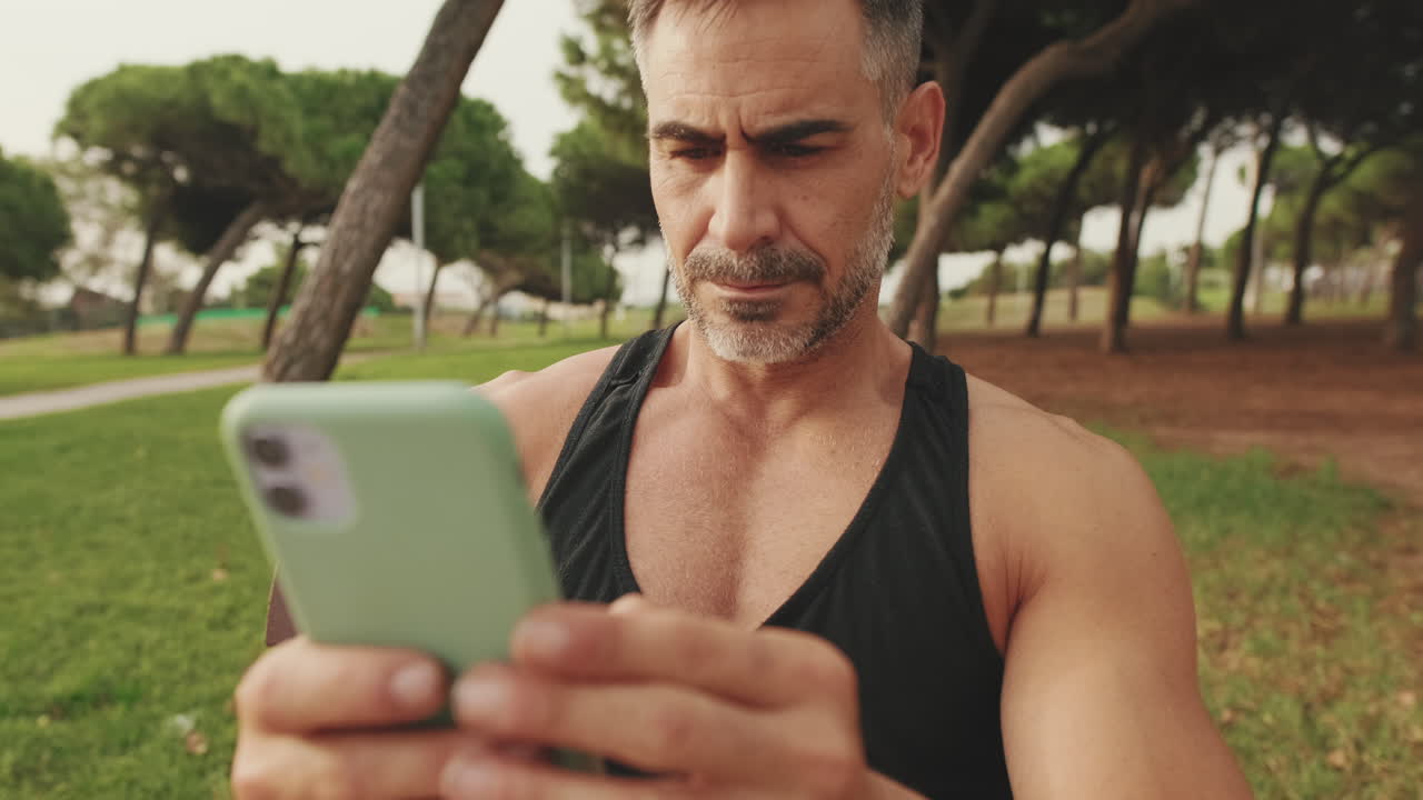 hombre usando teléfono móvil en el parque