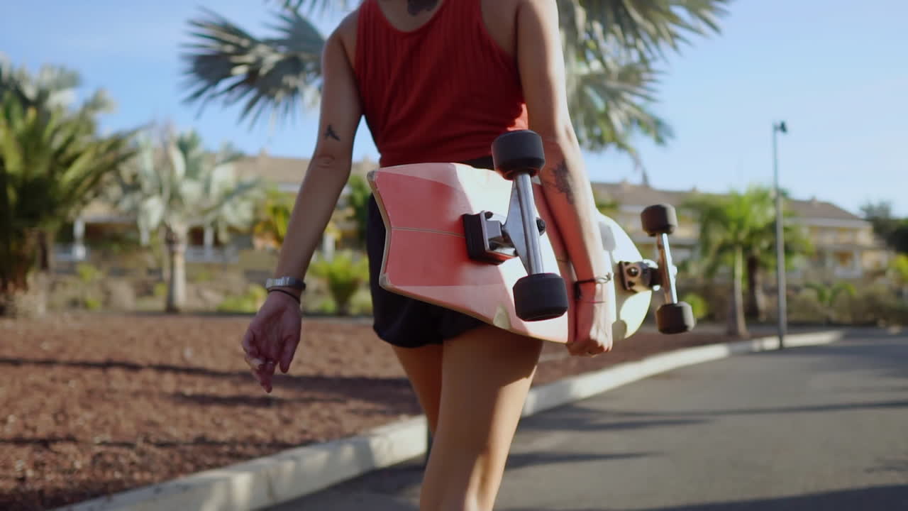en medio de las palmeras, dos amigos se dirigen al parque con patinetas, intercambiando conversaciones, risas y sonrisas radiantes, todo en cámara lenta, mientras la puesta de sol los baña en una luz cálida