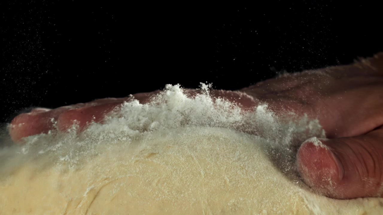 Slow Motion of Hand Pressing Dough and Flour Scattering