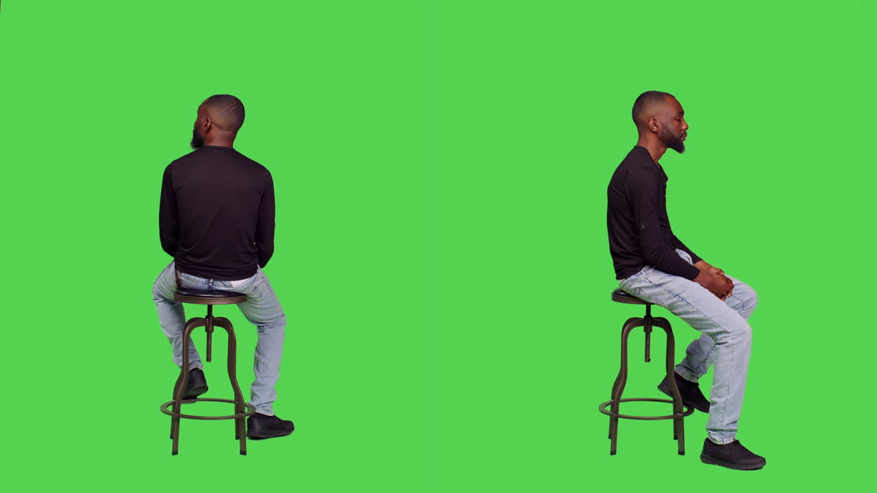 Man Sitting on Stool in Front of Green Screen