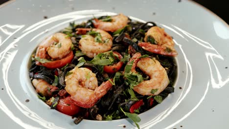 freshly served shrimp and tomato salad on white plate, close up