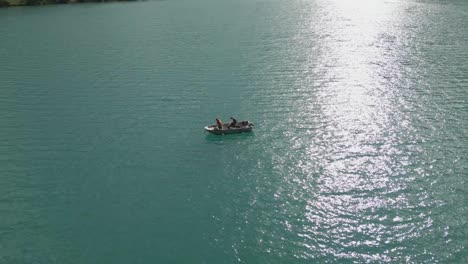 Boaters-enjoy-a-serene-ride-on-a-beautiful-turquoise-lake-under-a-bright-sunny-sky