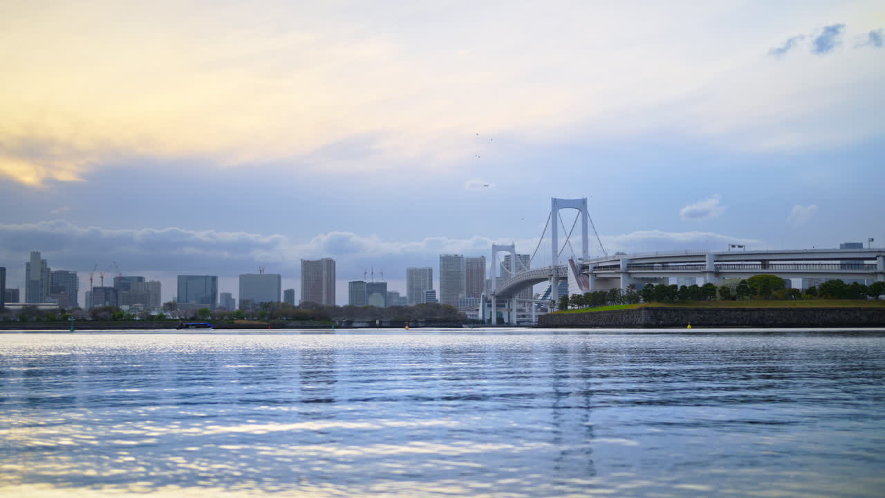 Distant view of the Rainbow Bridge and the skyline of Tokyo, Japan on a cloudy day