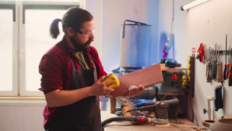 Artisan with safety glasses next to apprentice using sanding block