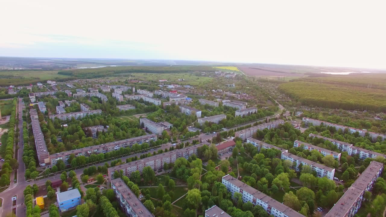 Town blocks of flats locating in the beautiful green area. Fantastic little cityscape with fine nature at backdrop. Aerial view.