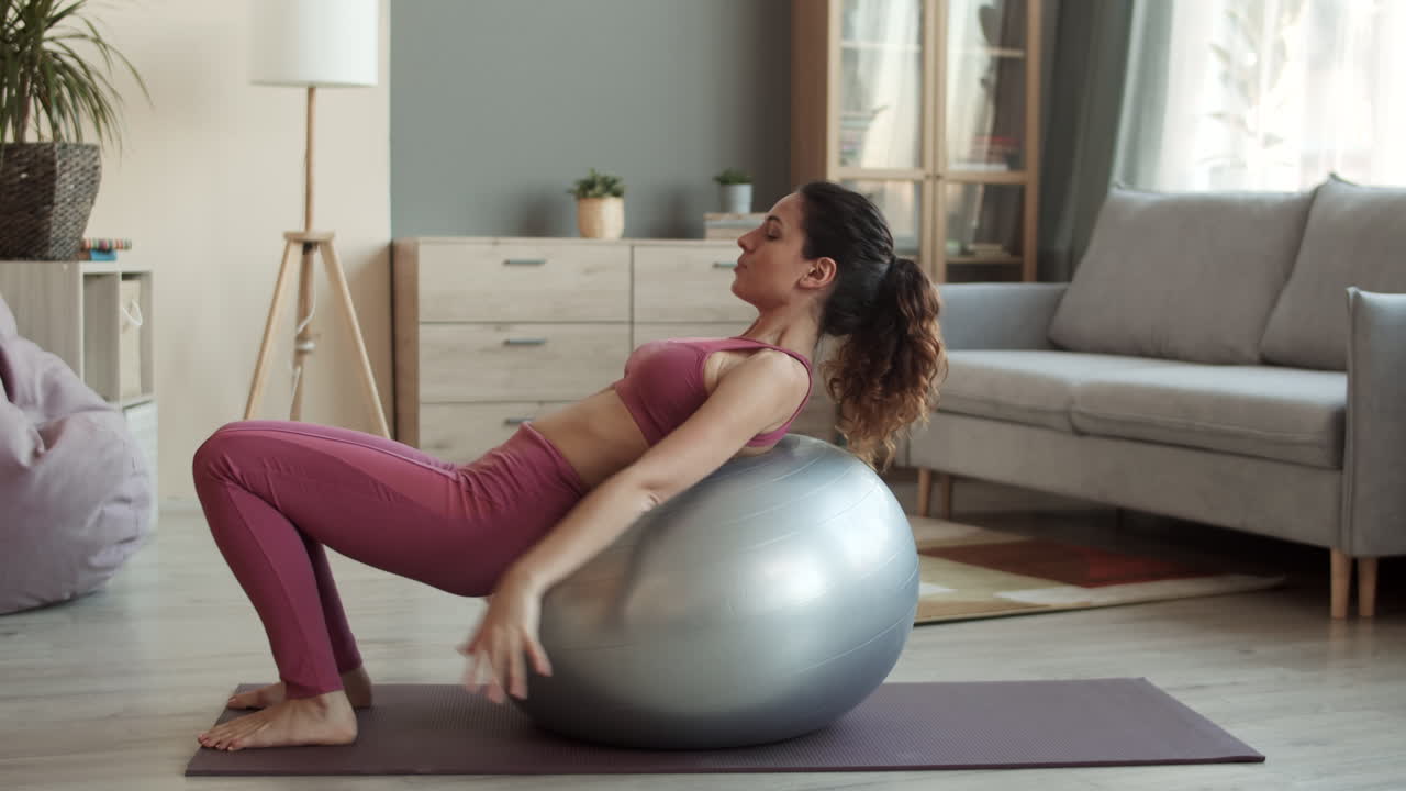 mujer joven estirando la espalda en fitball