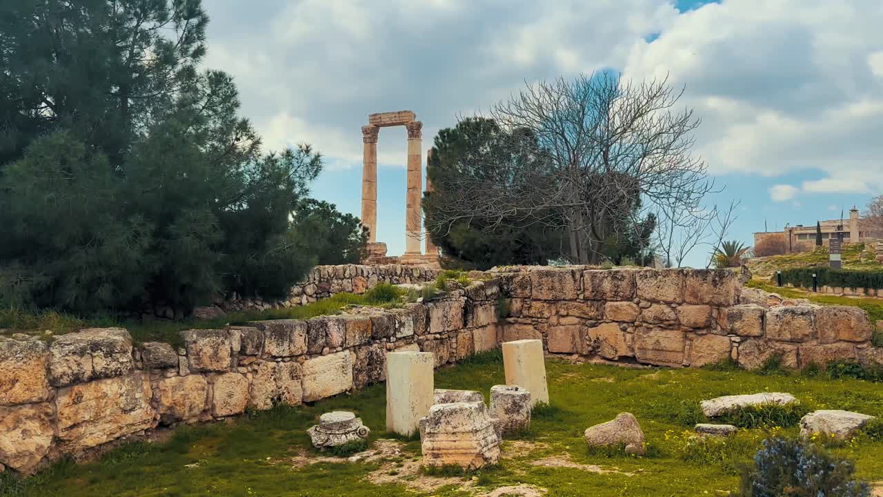 Citadel on a hilltop in Amman the ancient Roman Temple of Hercules. Stone ruins and greenery under bright skies highlight Jordan's historic architecture