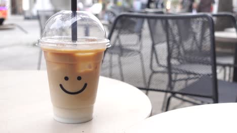 iced latte with smile face in outdoor cafe