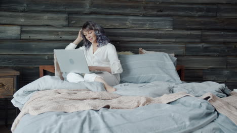 mujer trabajando desde la cama