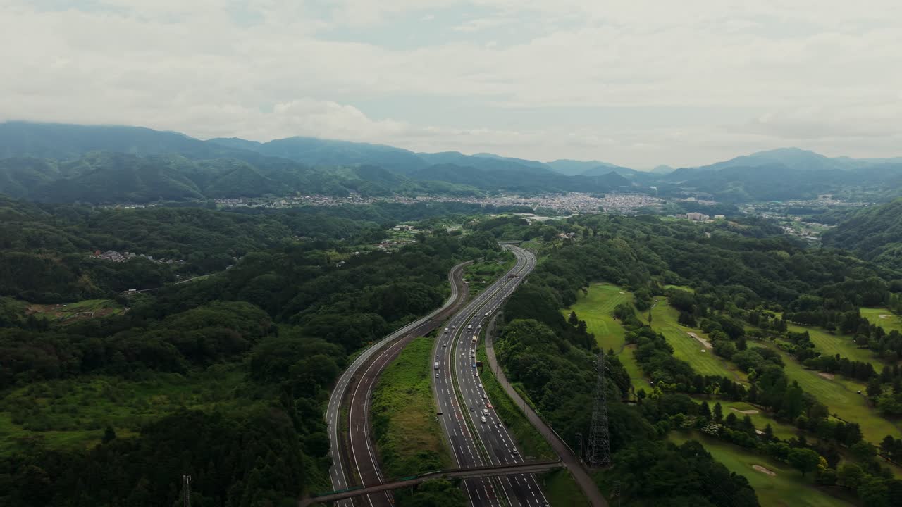 Aerial view of a highway winding through mountains and forest
