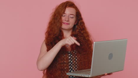 chica pelirroja trabajando en línea en la computadora portátil mostrando el pulgar hacia arriba positivo buena retroalimentación, como, ganar la lotería