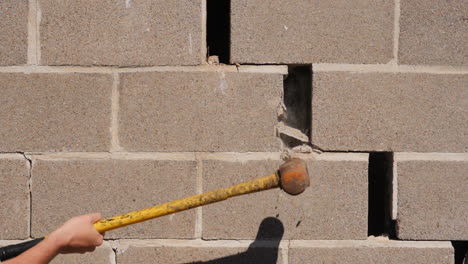 smashing wall with a hammer