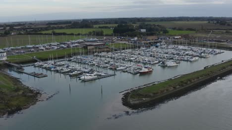 barcos amarrados en un muelle en una tarde fresca rodeada de campos verdes, bradwell en essex.