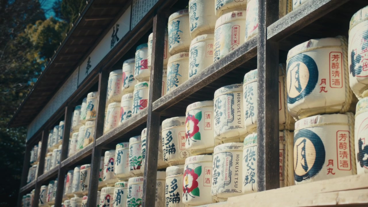 Tong sake dekoratif tradisional yang ditumpuk di rak kayu di kuil Tsurugaoka Hachiman-gu di Kamakura, masing-masing bertuliskan kaligrafi dan lambang pabrik sake yang berbeda, pemandangan umum di Jepang
