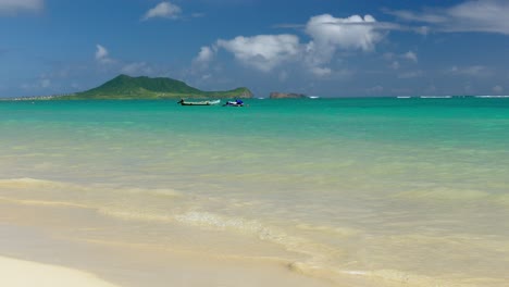 tropical beach with boats and jet ski