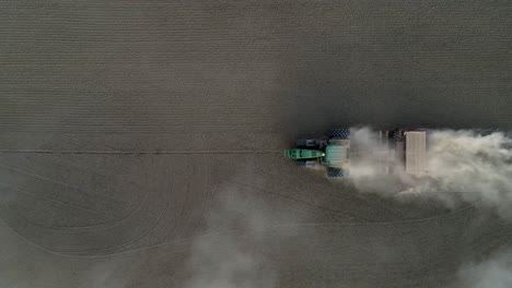 imágenes de drones de un tractor verde trabajando en un campo