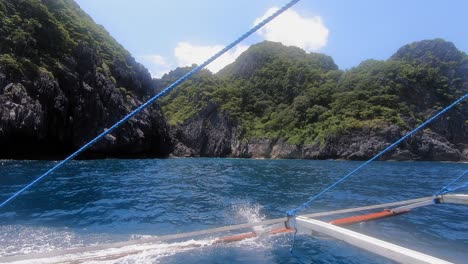 rocky islands with green vegetation in the philippines captured from a moving boat