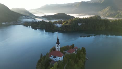 the beautiful church on lake bled during sunrise