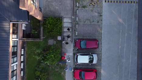 Aerial-to-down-shot-of-people-walking-in-path-beside-parking-area-in-city-of-Buenos-Aires