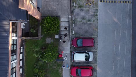 aerial to down shot of people walking in path beside parking area in city of buenos aires