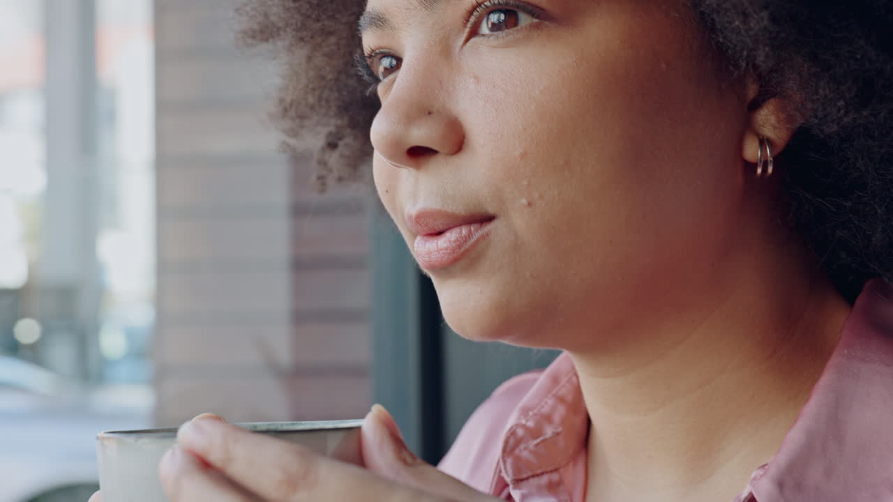 Mulher negra pensativa bebendo café.