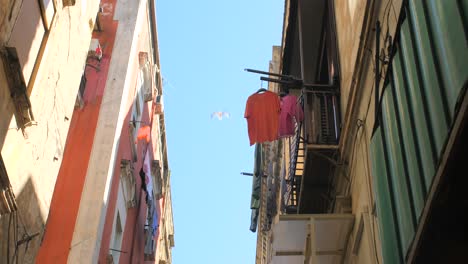 Hängende-Kleidung-Auf-Dem-Balkon-Eines-Alten-Wohngebäudes-Isoliert-Gegen-Den-Blauen-Himmel-Im-Quartieri-Spagnoli,-Neapel,-Italien