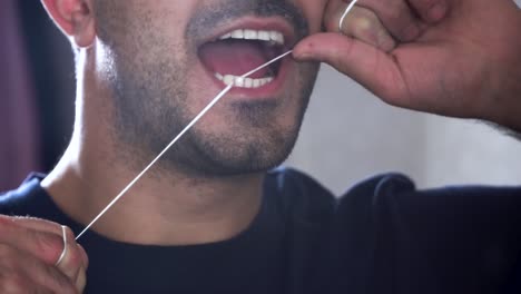 man flossing teeth