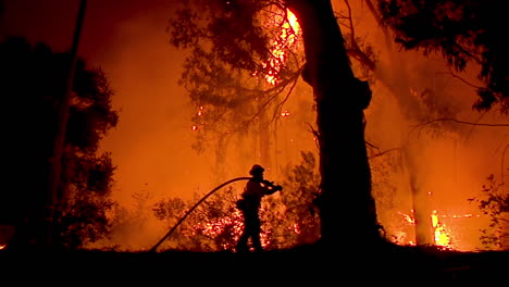 Ein-Feuerwehrmann-Steht-In-Silhouette-Und-Bekämpft-Einen-Riesigen-Hangbrand-Während-Des-Urlaubsfeuers