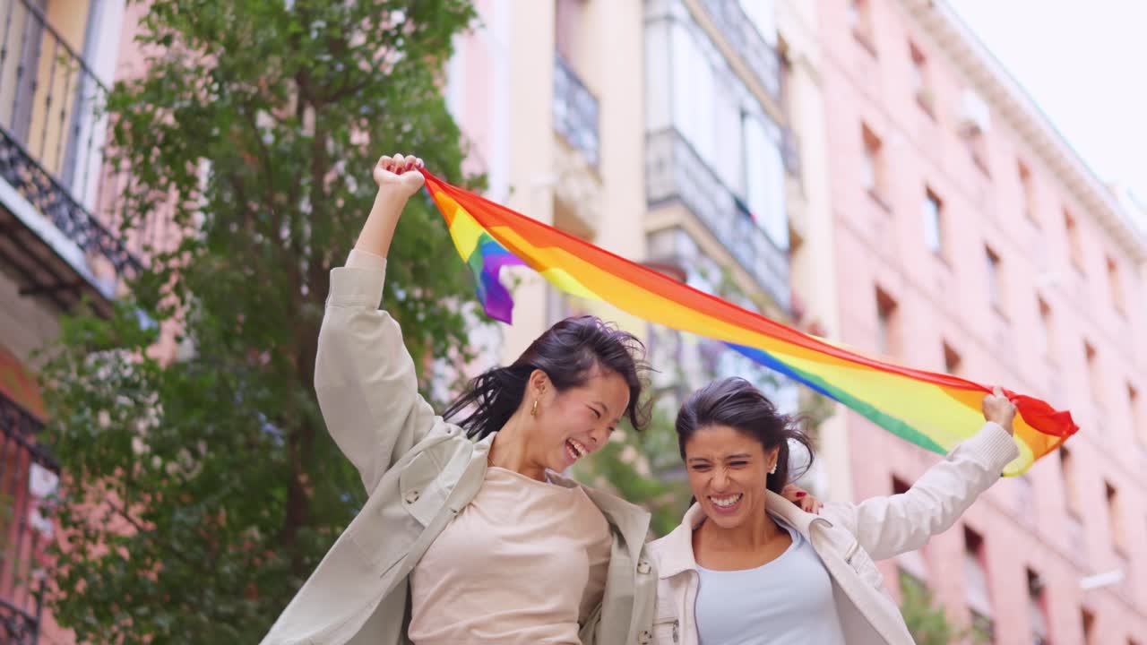 Joyful Young Women Celebrating with LGBTQ+ Pride Flag