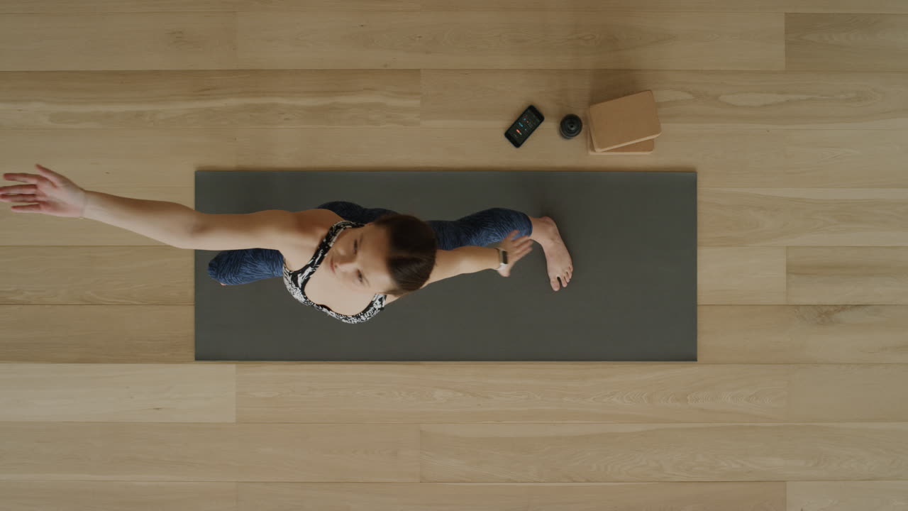 vista superior de una mujer de yoga practicando pose de guerrero inverso en un estudio de ejercicios disfrutando de un estilo de vida saludable, practicando meditación en una colchoneta de ejercicios