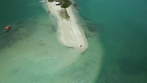 Un-Barco-Con-Fondo-De-Cristal-Anclado-En-Las-Aguas-Cristalinas-De-La-Tierra-De-Nadie,-Tobago