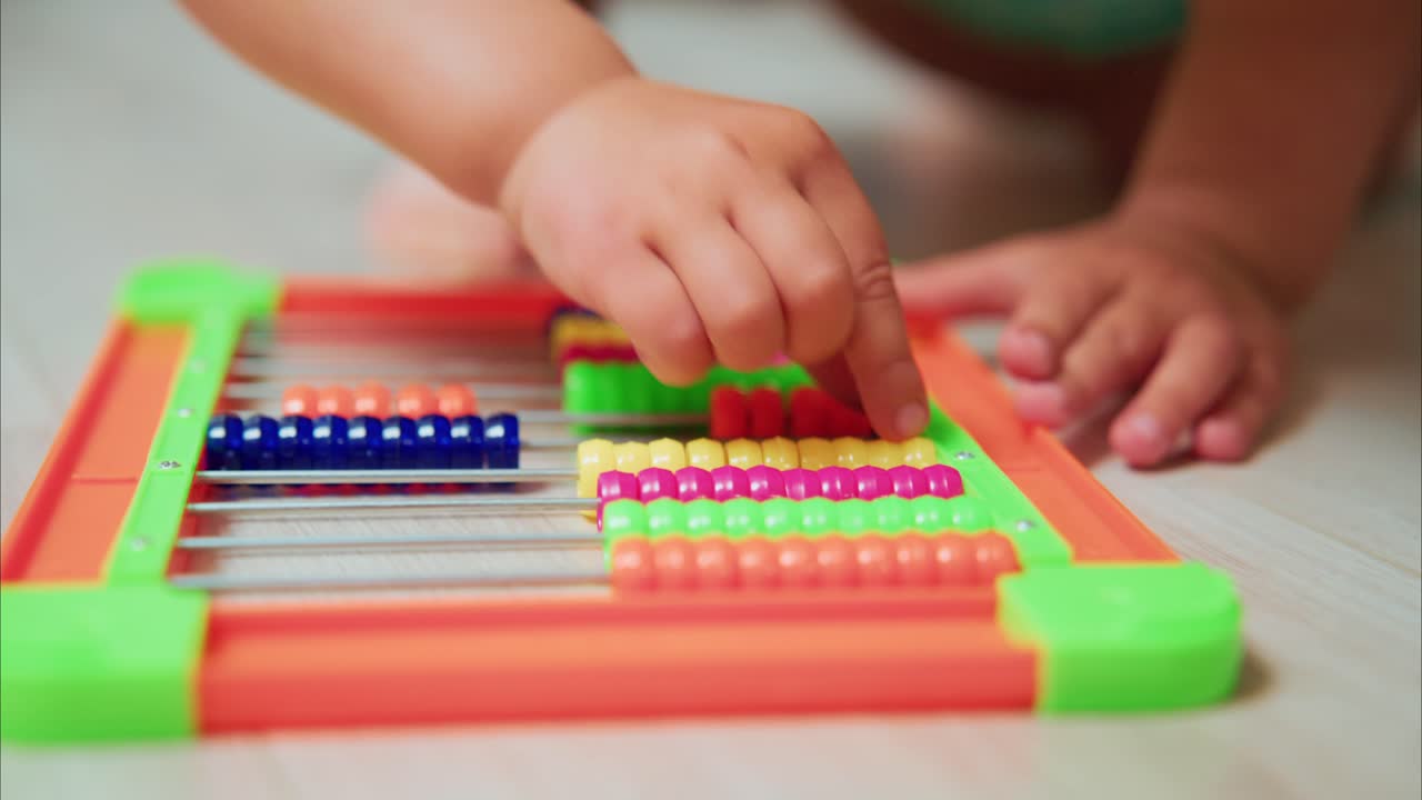 Engaging Early Learning: A Child's Playful Interaction with a Colorful Abacus in a Stimulating Environment for Skill Development