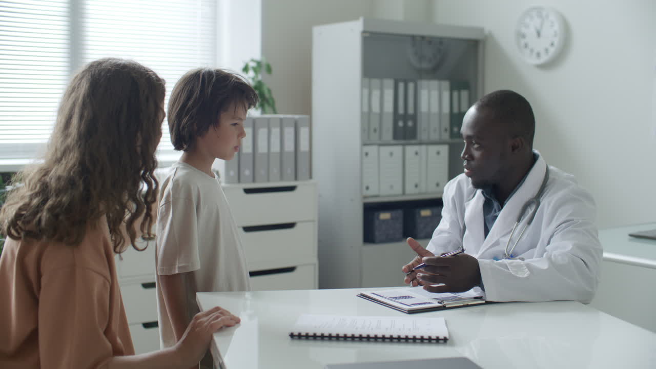 Pediatrician Talking with Mother and Young Boy during Medical Appointment