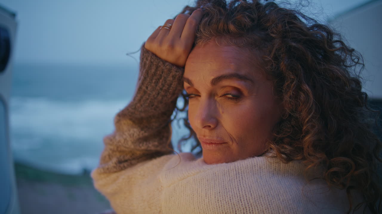 hermoso viajero descansando furgoneta de acampada en la noche de otoño primer plano. mujer madura
