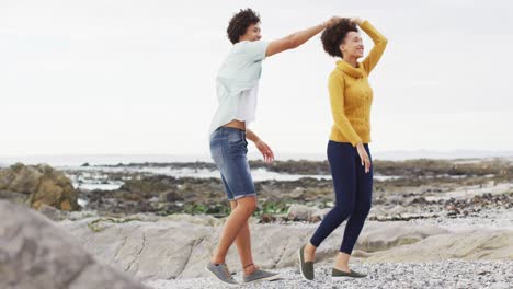 Afroamerikanisches-Paar-Tanzt-Gemeinsam-Auf-Den-Felsen-Am-Meer