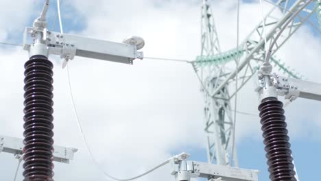muchos aislantes eléctricos de alto voltaje en la subestación de energía contra un fondo de cielo azul