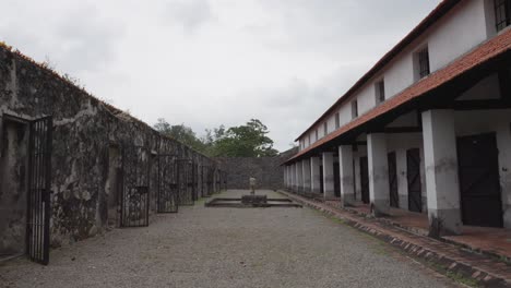 A-woman-walks-Inside-The-Oldest-Prison-In-Con-Dao-Island,-Ba-Ria-Vung-Tau,-Vietnam