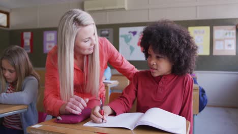 female teacher talking to a boy in the class at school