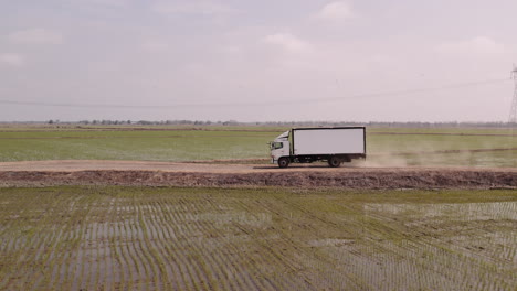 Drohnenaufnahme-Eines-Hino-Trucks,-Der-Reisfelder-In-Der-Ecuadorianischen-Stadt-Babahoyo-Befährt