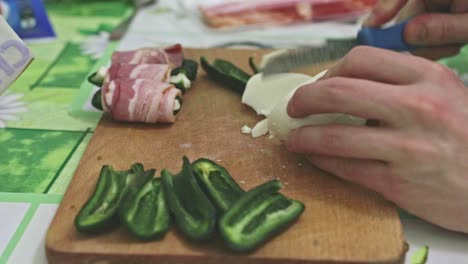 cutting mozzarella cheese before preparing stuffed jalapeno peppers for baking