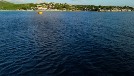 La-Inclinación-Del-Dron-Desde-Un-épico-Rayo-De-Luz-Se-Extiende-A-Través-Del-Océano-Abierto-Hasta-Un-Pequeño-Pueblo-Pesquero-Del-Caribe