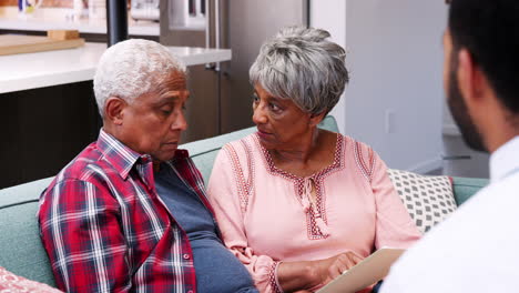 senior couple meeting with male financial advisor at home