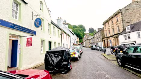 quaint town street with parked cars and shops