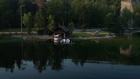 tourist rowing on a canoe at the calm water of bohinj lake at dawn in slovenia