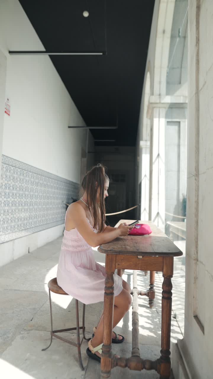 Girl sitting at a wooden table in an arcade