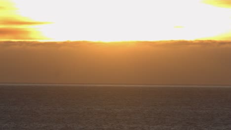 vuelo bajo sobre el océano con vista al atardecer