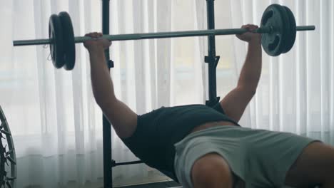 man doing heavy bench press workout with a barbell in the gym