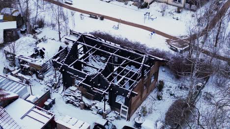 fire-burned-house-in-village,-winter-Snow